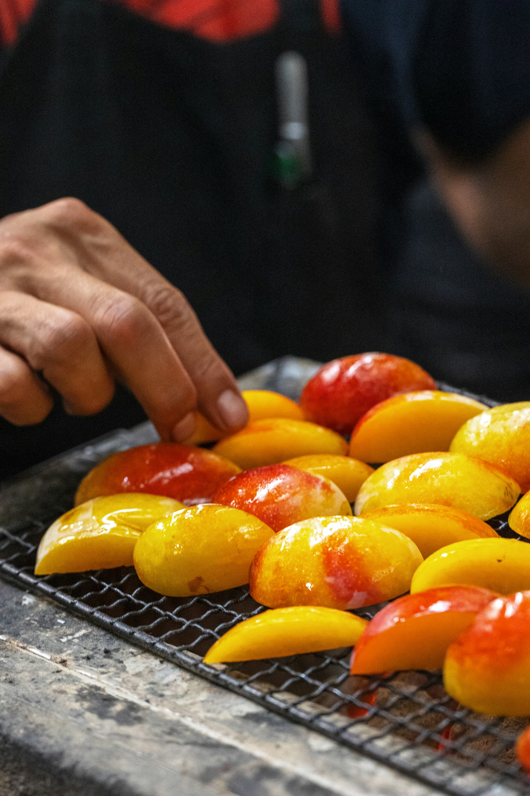 Colourful peppers being turned over a hot grill
